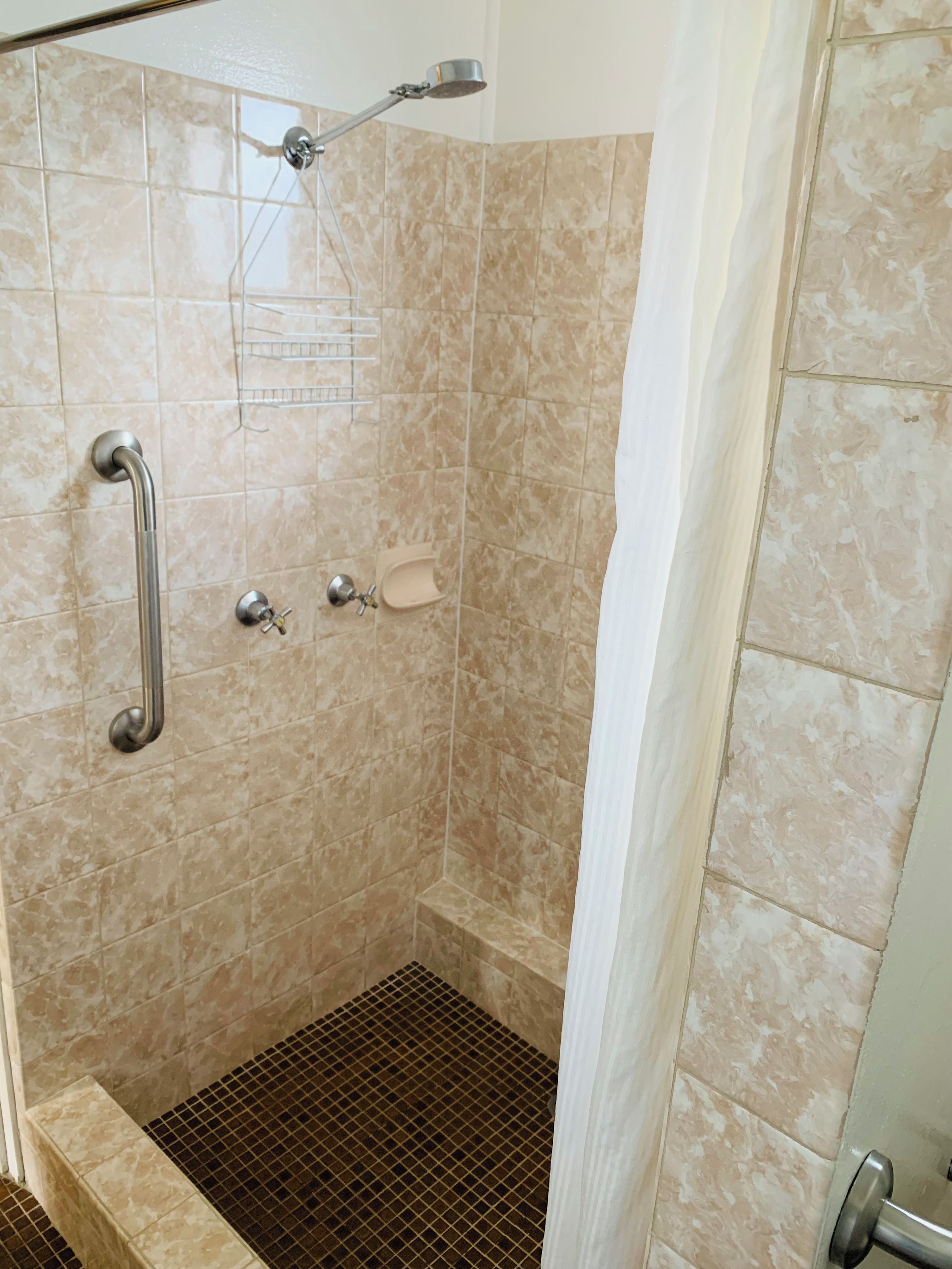 A shower with a handheld showerhead, a handheld showerhead, and a shower control.