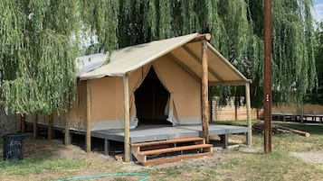 Uma estrutura em forma de tenda com teto plano e um banco na parte externa.