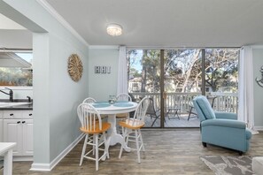 Relax in this open-plan living space with a dining area and sliding glass door leading to an outdoor deck.
