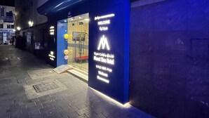 A hotel entrance with a blue facade and a sign indicating it is the Mount Sinai Hotel. - MOUNT SINA HOTEL BY AURA (Dubai)