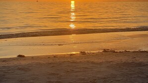 A beach at sunset with the sun reflecting on the water. - Dream Vacation Pool Home! On the Water! (Cape Coral)