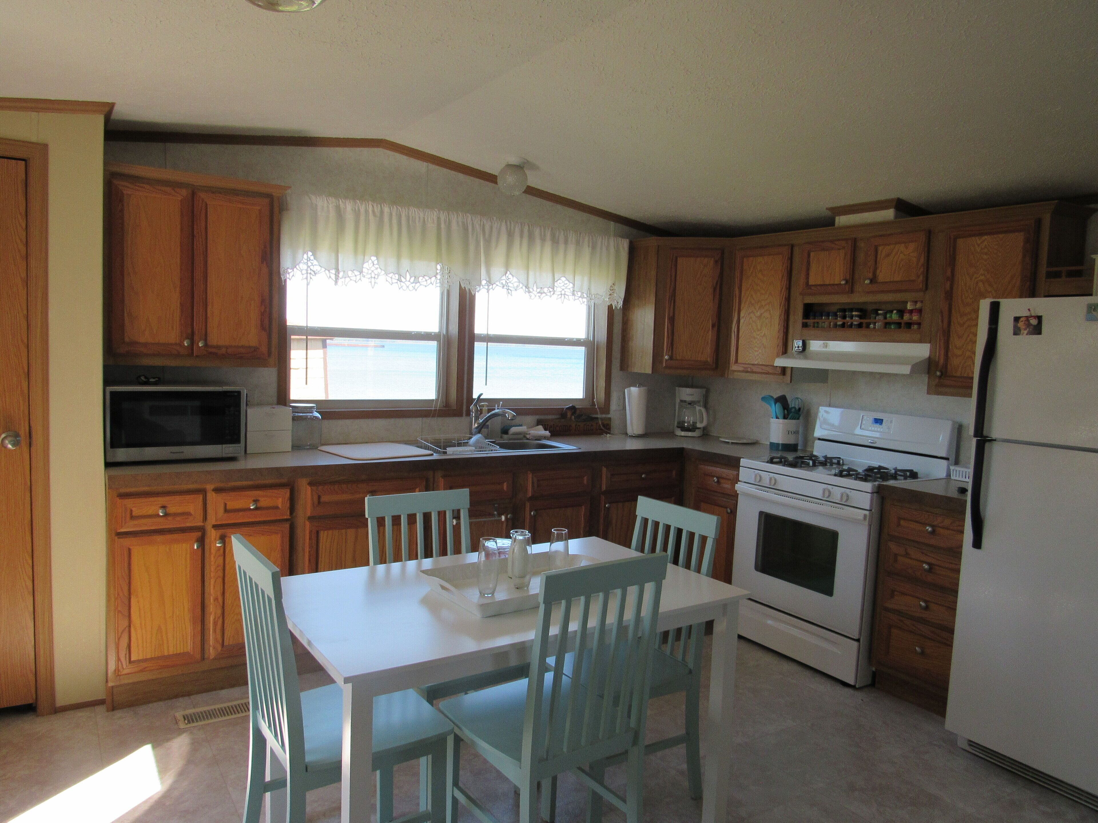 A kitchen with wooden cabinets, a white table, and chairs.