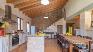 A spacious kitchen with a large island, wooden ceiling beams, and a stone wall. - LO D'EN CREUS - Fantastic country house with an above-ground pool, perfect for couples. Fr (Campos)