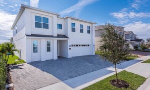 A modern two-story house with a garage, a driveway, and a well-maintained lawn. - Rent this Luxury 5 Star Villa on Encore Resort at Reunion, Orlando Villa 5456 (Orlando)