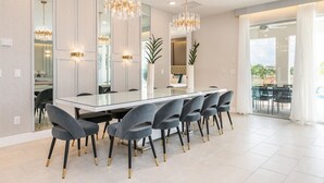 Un espace de restauration moderne, doté d’une longue table, de nombreuses chaises et d’un éclairage décoratif.