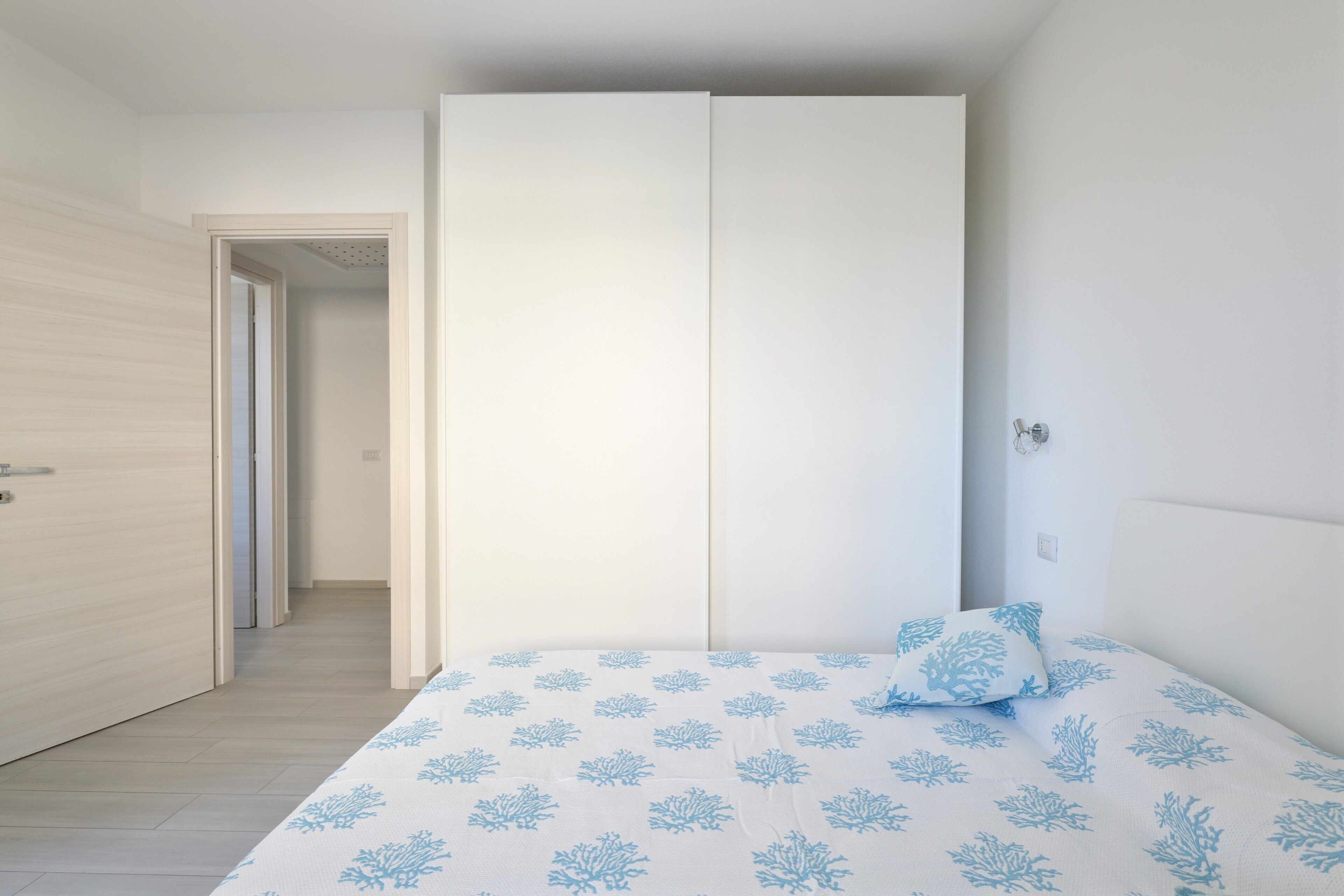 Una camera da letto con un letto, un armadio e una porta che dà su un'altra stanza.