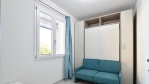 A room with a window, a sofa, and a wardrobe.