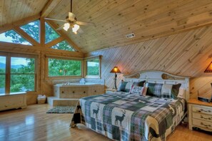 A cabin bedroom with a large bed, a window seat, a bathtub, and a ceiling fan. - Aska Retreat • Jacuzzi • Hot Tub • Near Toccoa River (Blue Ridge)