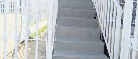 A concrete staircase with white railings leading to a building entrance.