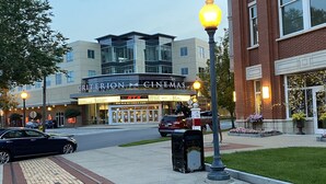 A Criterion Cinemas building with a modern design, a parking lot, and a street lamp.