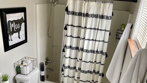 A bathroom with a toilet, sink, shower, and a towel rack. - Sellwood Custom Private Space (Portland)