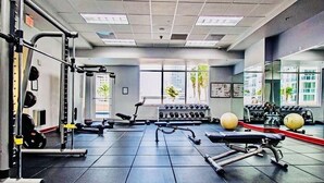 A gym with various exercise equipment, including weight machines, dumbbells, and exercise balls. - Mesmerizing Studio Brickell +Free Parking + Gym+Pool (Miami)