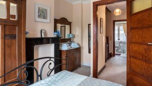 A bedroom with a bed, a dresser, a mirror, and a door leading to another room. - Jasmine by Interhome (Mol)