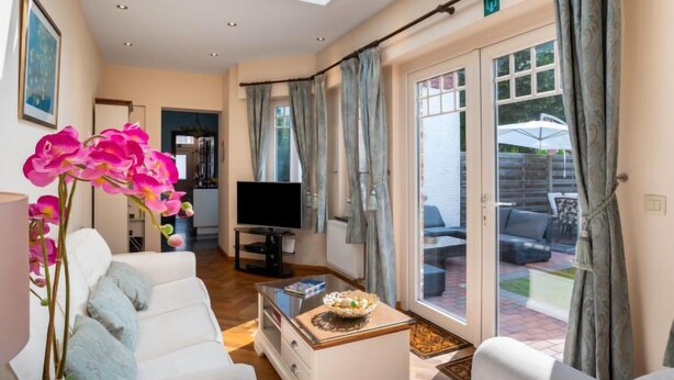 A spacious living room with a sofa, coffee table, and a flat-screen TV. - Jasmine by Interhome (Mol)