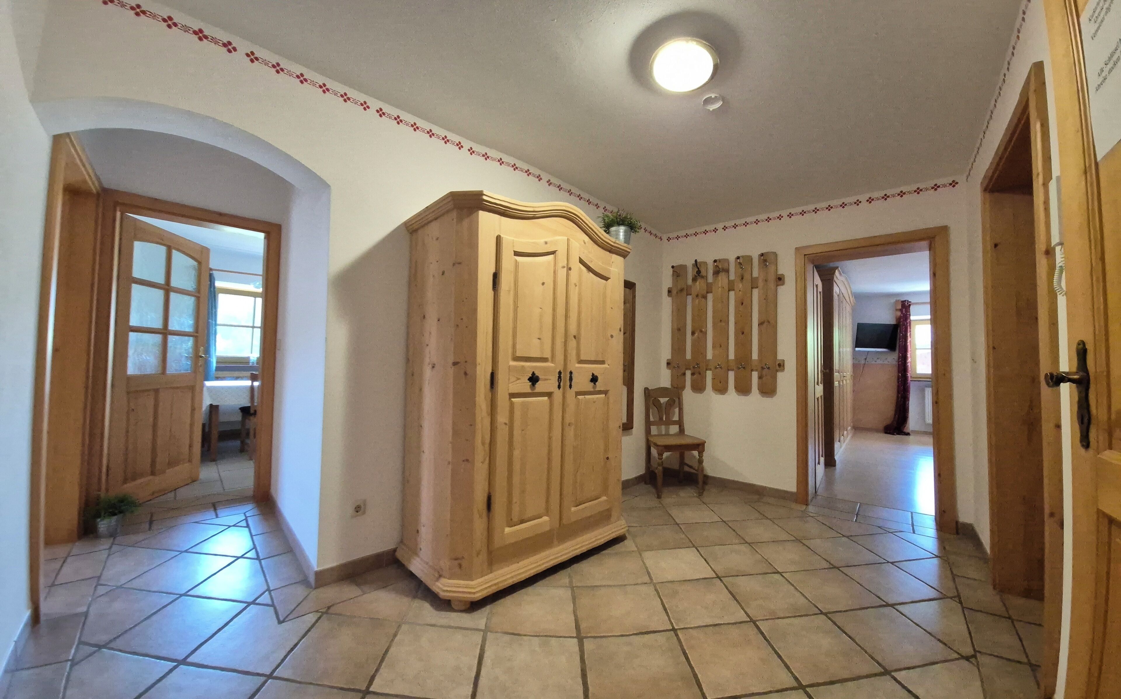 Une pièce comprenant une armoire en bois, une chaise et une étagère en bois fixée au mur.