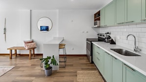A compact kitchen with a dining area, a built-in stove, and a sink. - Charming condo walking to beach and town (Tamarindo)