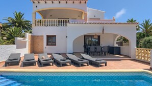 A two-story villa with a swimming pool, sun loungers, and outdoor furniture. - Wonderful and cheerful villa in Javea, Costa Blanca, Spain  with heated pool for 6 persons (Javea)