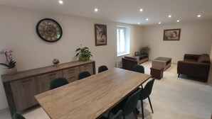 Een moderne keuken met een houten aanrecht, een eettafel met stoelen en een raam met gordijnen.