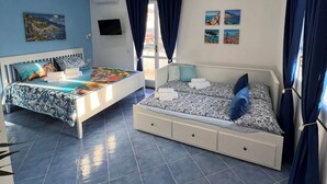 A bedroom with two beds, a TV, and artwork on the walls. - One-bedroom Apartment with Pool, Playground and breathtaking view (Piazza-Tralia-Pendolo)