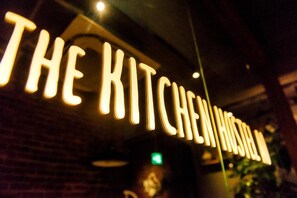 Illuminated signage reading "THE KITCHEN HOSTEL" in a dimly lit environment. - Kalakaua Inn The Kitchen Hostel Ao (Naha)
