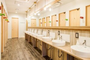 A hotel bathroom with multiple sinks, wooden cabinets, and mirrors. - Kalakaua Inn The Kitchen Hostel Ao (Naha)