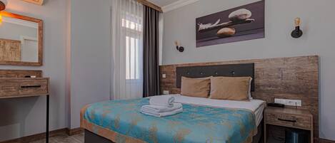 Una camera da letto con un letto, un comodino, una cassettiera, un condizionatore d'aria, una finestra con tende e un'opera d'arte appesa al muro.