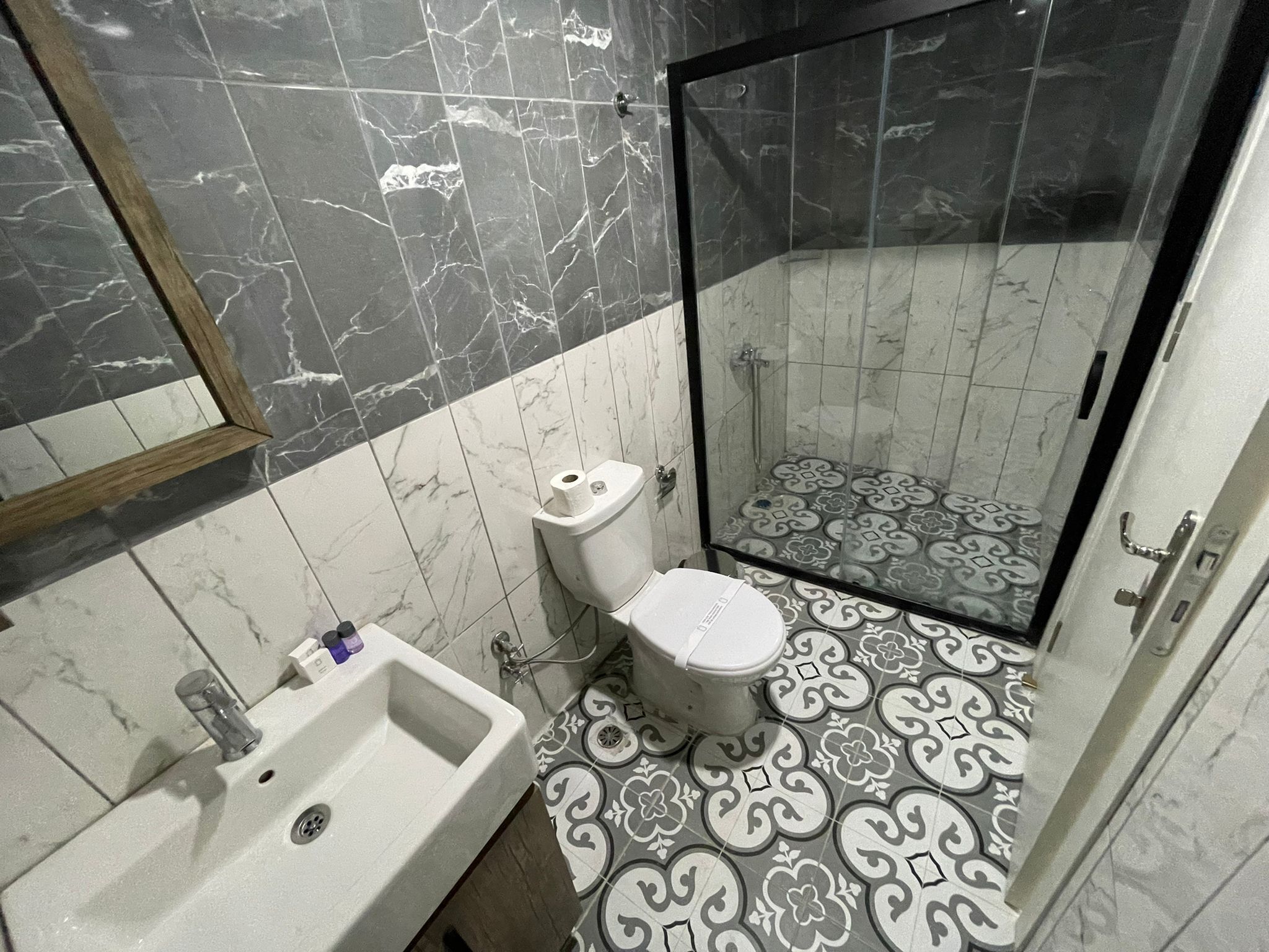 Un baño con inodoro, lavabo y ducha.