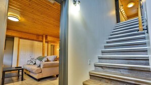 A staircase with wooden steps and a handrail, leading to a landing with a light fixture.