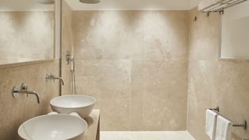 Un baño moderno con dos lavamanos grandes, ducha y bañera.
