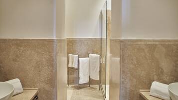 A modern bathroom with a large mirror, a glass shower enclosure, and two sinks.