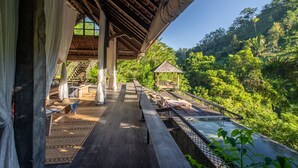 A wooden deck with a view of a lush forest, a small gazebo, and a pool area. - Buahan, A Banyan Tree Escape (Payangan)