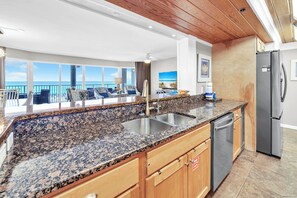 A kitchen with granite countertops, stainless steel appliances, and wooden cabinets.