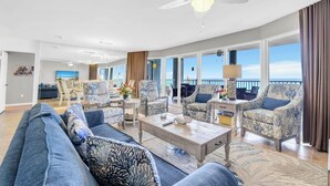 A spacious living room with a large sofa, patterned armchairs, a coffee table, and a view of the ocean. - Private Balcony~ Pool~Grills~3BR Long Beach Resort #2-201 (Panama City Beach)