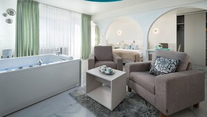 A modern bathroom with a bathtub, two armchairs, a small table, and a fluffy rug. - Elegante Apartments - Adults only (Wladyslawowo)