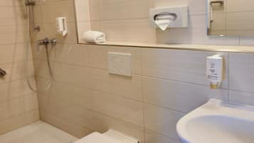 Un baño moderno con ducha, inodoro y lavamanos.