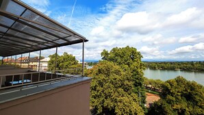 Terraza en la azotea con vistas a un río y árboles circundantes.