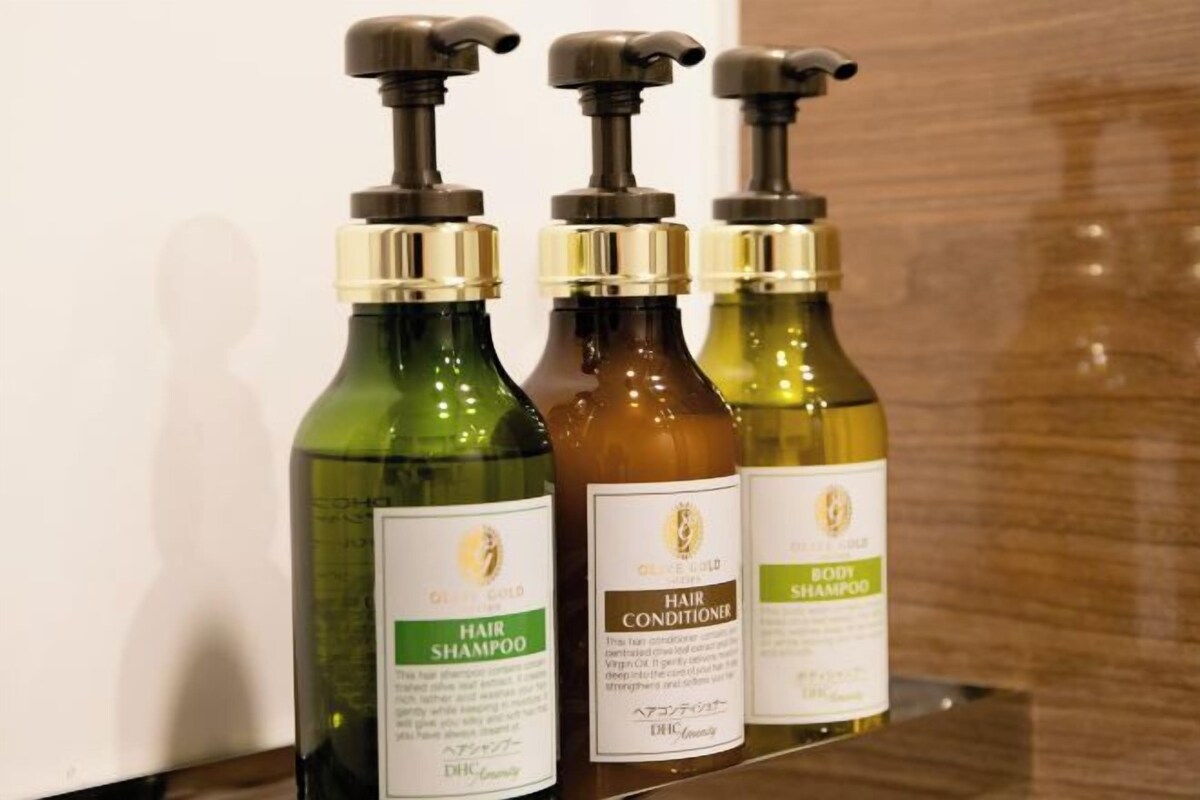 Tres botellas de productos para el cuidado del cabello sobre una estantería.