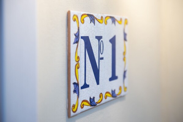 A wall-mounted sign with the number "1" and decorative elements. - Gartenappartement in der Finca / Spanische Rhön (Hünfeld)