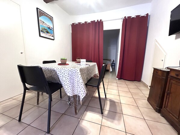 Un comedor con una mesa, sillas, una planta en maceta y un letrero que dice "BARRIO".