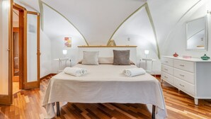 A bedroom with a bed, bedside tables, a dresser, and a mirror.