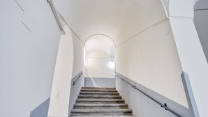 A staircase with a handrail, leading to an arched doorway.