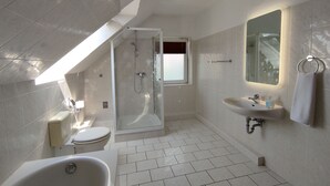 A modern bathroom with a shower, toilet, and bathtub. - Ferienwohnung Family Basic in Kiel (Kiel)