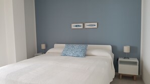 A bedroom with a bed, two bedside tables, and two wall-mounted lamps. - Appartamento Sulla Spiaggia (Villafranca Tirrena)