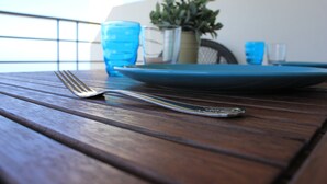 A wooden table with a blue plate, a fork, and a glass. - Appartamento Sulla Spiaggia (Villafranca Tirrena)