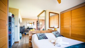 A bedroom with a wooden bed, a large mirror, and a wardrobe. - VILLA SUNSET VI4236 By Riviera Holiday Homes (Niza)