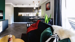 Un salon moderne avec un canapé, une table basse et, au fond, un coin repas.