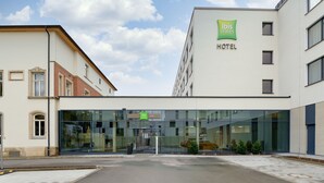 A modern hotel with a glass facade, a green "ibis styles" sign, and a "HOTEL" sign on the building. - Ibis Styles Coburg (Coburg)