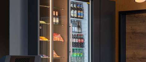 Un minibar con diferentes bebidas y aperitivos.
