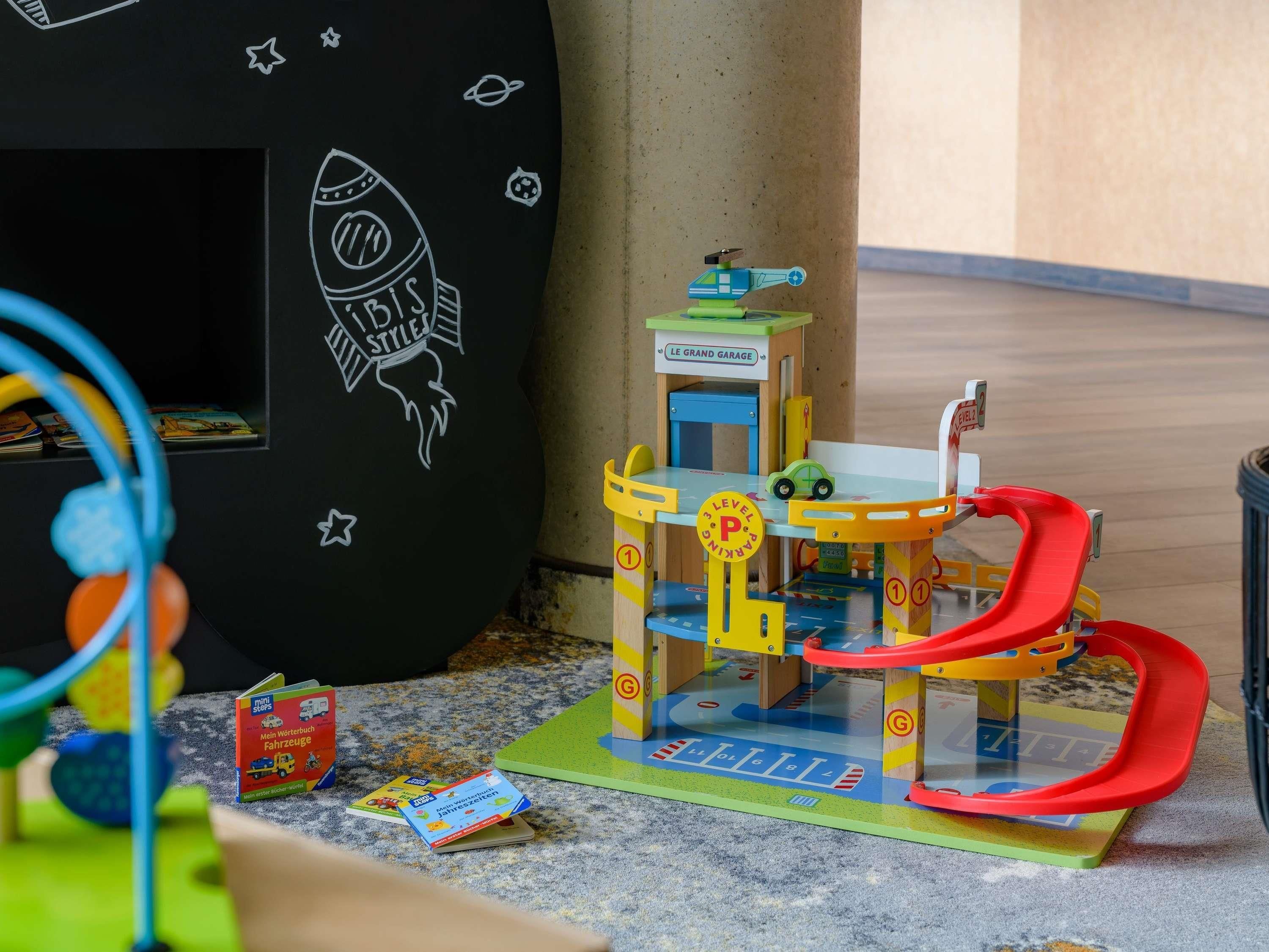 A toy play area with a rocket, a garage, and a car.
