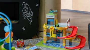 A toy play area with a rocket, a garage, and a car.